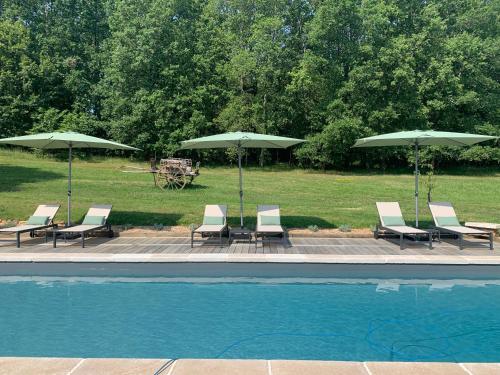 a group of chairs and umbrellas next to a pool at Le Clos 1855 in Saint-Laurent-des-Bâtons