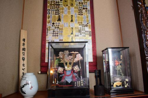 a shelf with a glass box with a figurine in it at OMOLOSO Hostel　オモロソウ ホステル in Beppu