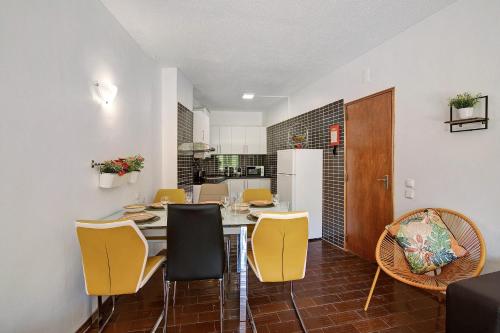 uma sala de jantar com uma mesa e cadeiras amarelas em Hanna's Sunny Apartment em Albufeira