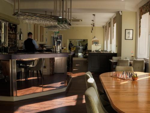 a man sitting at a bar in a kitchen with a table at The Spa Hotel in Royal Tunbridge Wells