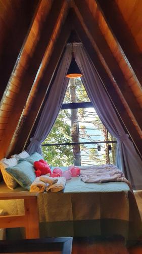 uma cama num quarto com uma janela em CABANAS DA MATA NP em Nova Petrópolis