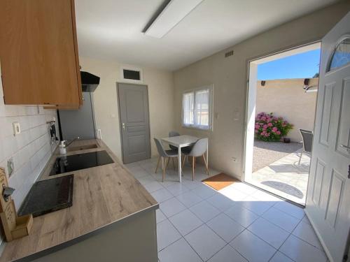 uma cozinha com uma mesa e vista para um pátio em Maison individuelle em Villecomtal-Sur-Arros