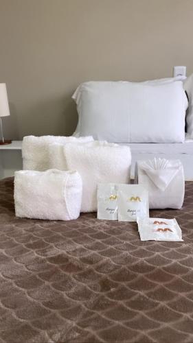 a bedroom with a bed with towels on the floor at Pousada Mercosul in Alegrete