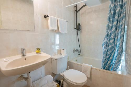a bathroom with a sink and a toilet and a tub at Mike's House Jerusalem in Jerusalem