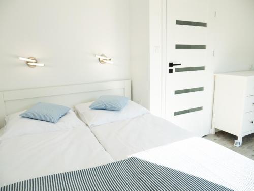 1 dormitorio con 1 cama con 2 almohadas en Domki Kapitalne en Władysławowo