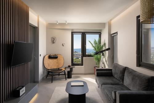 a living room with a couch and a tv at Apikia Santorini in Pirgos