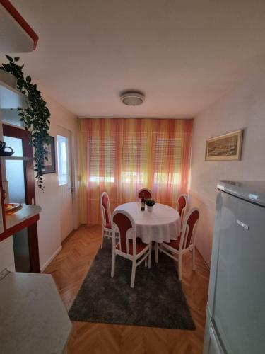eine Küche mit einem Tisch und Stühlen im Zimmer in der Unterkunft Drago Apartman in Šibenik