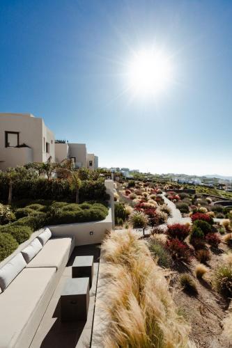 a view of a garden with benches and plants at Apikia Santorini in Pirgos