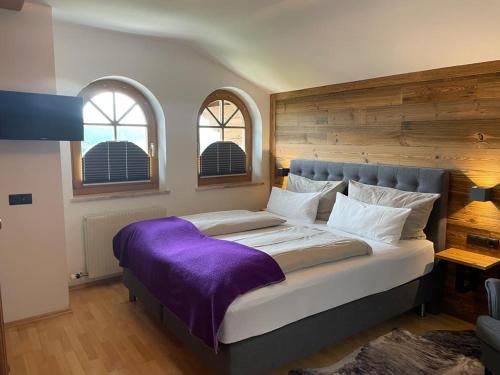 アルテンマルクト・イム・ポンガウにあるAppartement Thunhart Wilfried&Elisabethのベッドルーム(紫の毛布を使用した大型ベッド1台付)