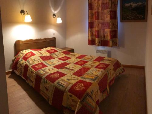 una camera con un letto con una trapunta sopra di Appartement Valloire, 3 pièces, 5 personnes - FR-1-263-224 a Valloire