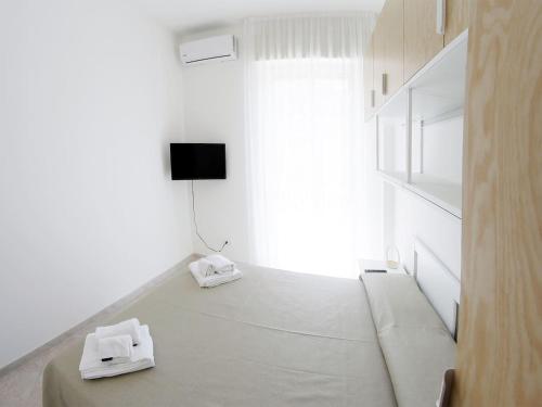 ロゾリーニにあるSikelia holiday houseの白い部屋(テレビ付)、床にタオルが備わります。