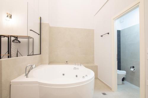 baño blanco con bañera y aseo en Athens Connection Apartments, en Atenas