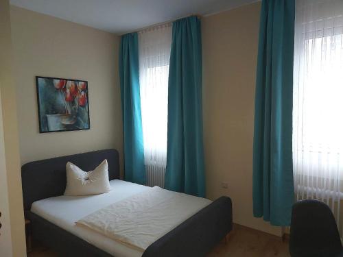 a bed in a room with blue curtains and a window at An der Stadthalle in Braunschweig