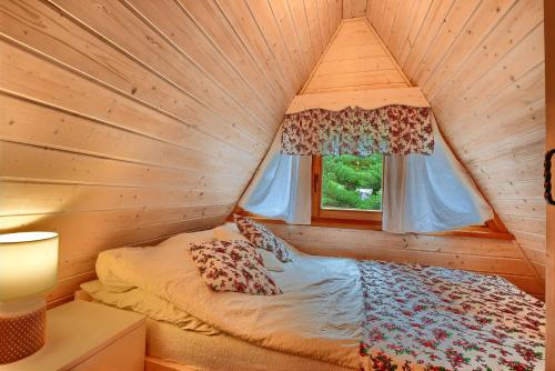 a bed in a wooden room with a window at Górska Pasja Istebna in Istebna