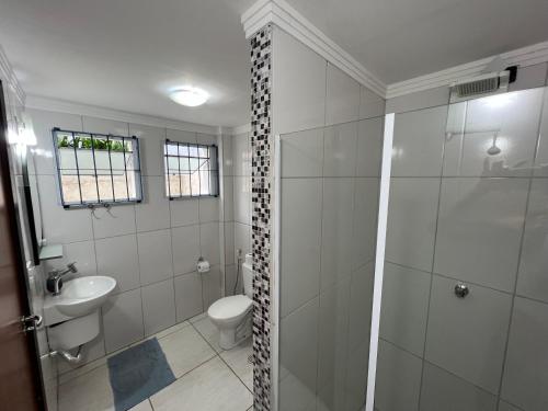 a bathroom with a shower and a toilet and a sink at Pura Vida Ubatuba Suítes in Ubatuba