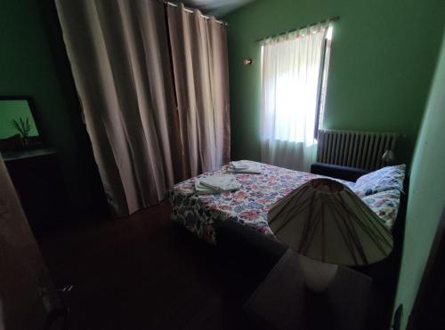 a small bedroom with a bed and a window at B&B Da Dodo' in Calizzano