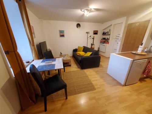 Il dispose d'une cuisine et d'un salon avec une table et un réfrigérateur. dans l'établissement Le Pied-à-Terre de Fenières - T2 à 10mins de Genève et du CERN !, à Thoiry