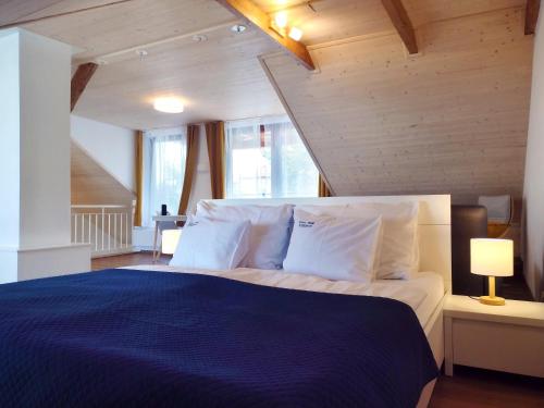 - une chambre avec un lit bleu et des oreillers blancs dans l'établissement Apartmán Kollarovi, à České Budějovice