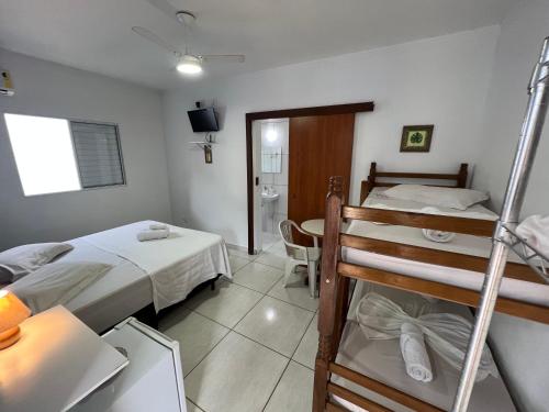 a bedroom with two bunk beds and a bathroom at Pura Vida Ubatuba Suítes in Ubatuba