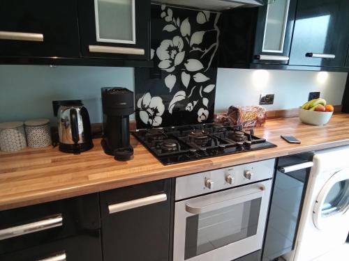 een keuken met een fornuis oven naast een magnetron bij Ocean City Apartment-with parking in Plymouth