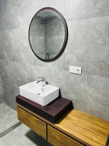 a bathroom with a sink and a mirror on the wall at villa gardens in K'obulet'i