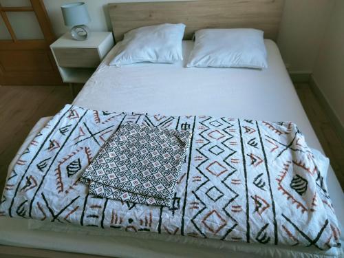 - un lit avec une couette blanche et 2 oreillers dans l'établissement Grand appartement de 4 Chambres moderne et lumineux, entièrement meublé, à Belfort