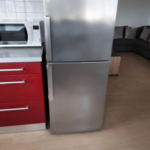 un réfrigérateur en acier inoxydable dans une cuisine avec un micro-ondes dans l'établissement Grand appartement de 4 Chambres moderne et lumineux, entièrement meublé, à Belfort