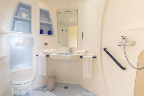 een badkamer met een toilet, een wastafel en een douche bij Hotel-Restaurant Stand'Inn in Foetz