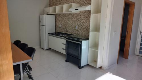 Wana casa 1 Requinte e conforto في ساو جوزيه دو ريو بريتو: مطبخ مع موقد وثلاجة