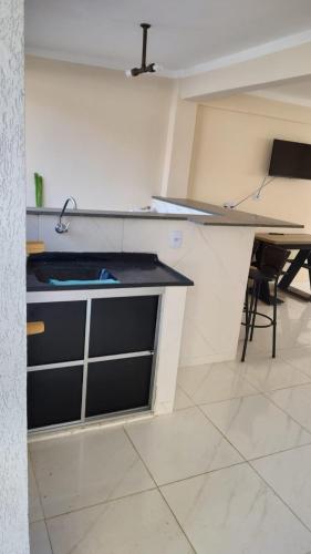 a kitchen with a counter and a table in a room at Wana casa 1 Requinte e conforto in Sao Jose do Rio Preto
