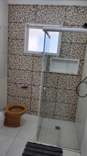 a bathroom with a shower with a toilet and a window at Wana casa 1 Requinte e conforto in Sao Jose do Rio Preto
