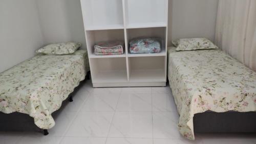 a bedroom with two beds and a white tile floor at Wana casa 1 Requinte e conforto in Sao Jose do Rio Preto