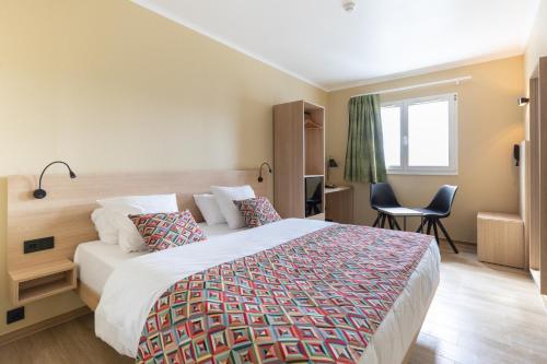 Un pat sau paturi într-o cameră la Hotel-Restaurant Stand'Inn