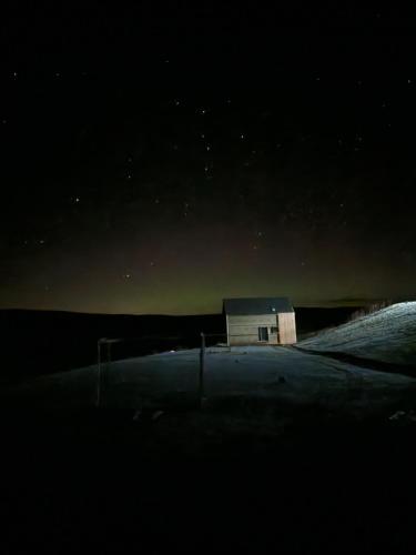 a small house in the middle of a field at night at Tarset Tor - Bothy 2 in Hexham