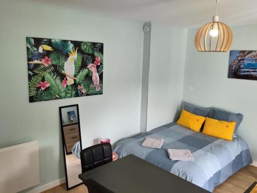 sypialnia z łóżkiem, stołem i lustrem w obiekcie appartement refait à neuf pour 3 personnes avec wi-fi w mieście Vic-sur-Cère