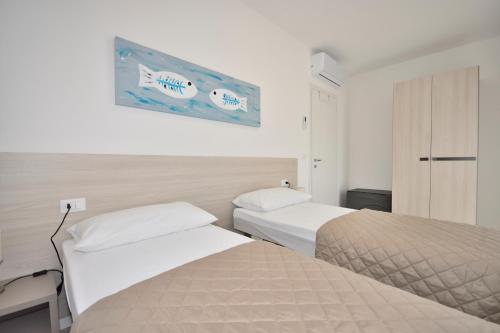 a hotel room with two beds and a picture on the wall at Condominio Aliante in Bibione