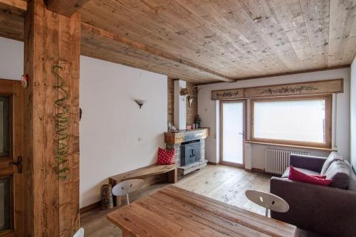 a living room with a wooden ceiling and a table at Estate in montagna in San Vito di Cadore