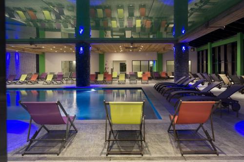 a pool with chairs and a pool of water at CGH Résidences & Spas Les Chalets de Flambeau in Lanslebourg-Mont-Cenis
