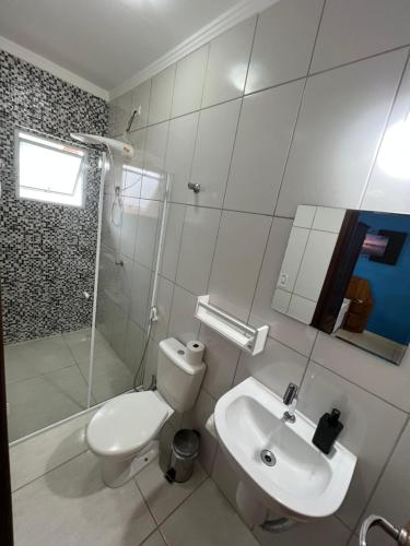 a bathroom with a toilet and a sink and a shower at Pura Vida Ubatuba Suítes in Ubatuba