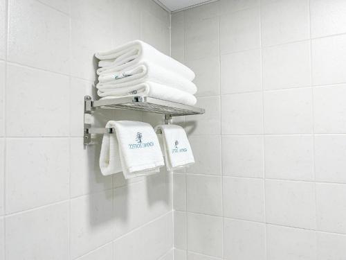 a bathroom with white towels hanging on a wall at Cosmos Living Spacious Studio With Balcony in Dubai