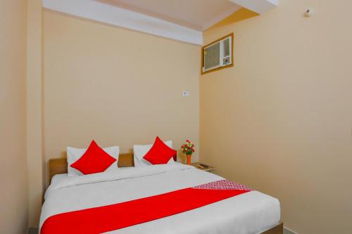 加濟阿巴德的住宿－Flagship The Siddhartha，卧室配有红色和白色的床和红色枕头
