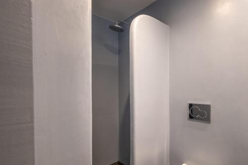 a hallway with a white wall with a light on it at Sand Gem - Beach Apartments in Perivolos