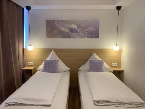 2 camas en una habitación de hotel con 2 luces en Meerbuscher Hof en Meerbusch