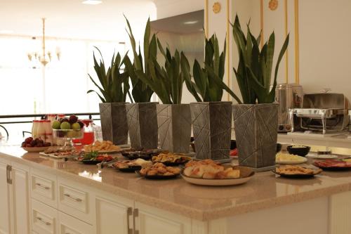 a kitchen counter with plates of food and plants at Tashkent Hotel in Nukus