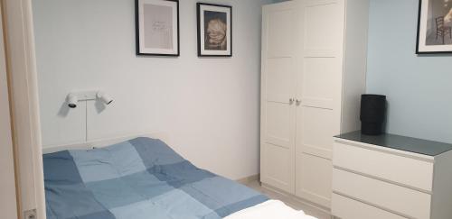 a white bedroom with a blue bed and white cabinets at Dom na górce 