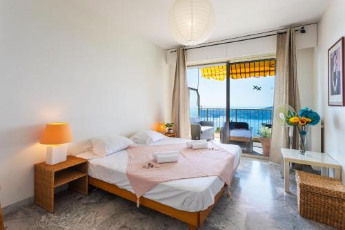 une chambre avec un lit et une grande fenêtre dans l'établissement LE CALIFORNIA 3 AP4366 By Riviera Holiday Homes, à Villefranche-sur-Mer
