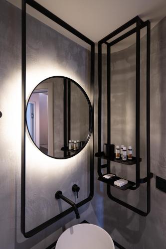 a bathroom with a mirror and a white sink at Apikia Santorini in Pirgos