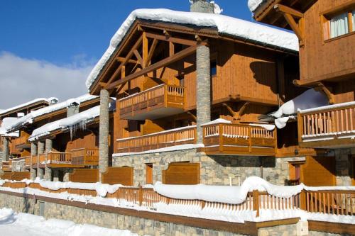 une cabane en rondins avec de la neige sur le toit dans l'établissement Chataigne, cosy 3 bedroom apartment with great views, à Sainte-Foy-Tarentaise