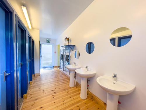 a bathroom with two sinks and two mirrors at Tarset Tor Bunkhouse in Hexham