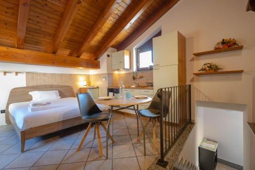 1 dormitorio con 1 cama, mesa y sillas en Inn Aosta Apartments, en Aosta